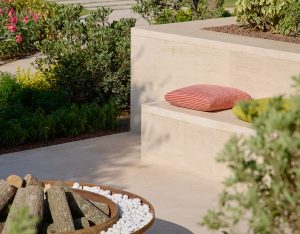 Exterior shot of a Bulgari Bodrum mansion's terrace. The landscape is rich and green and there is an inviting fireplace and seating area for gathering.